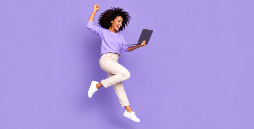 femme joyeuse dynamique avec un PC portable dans une main